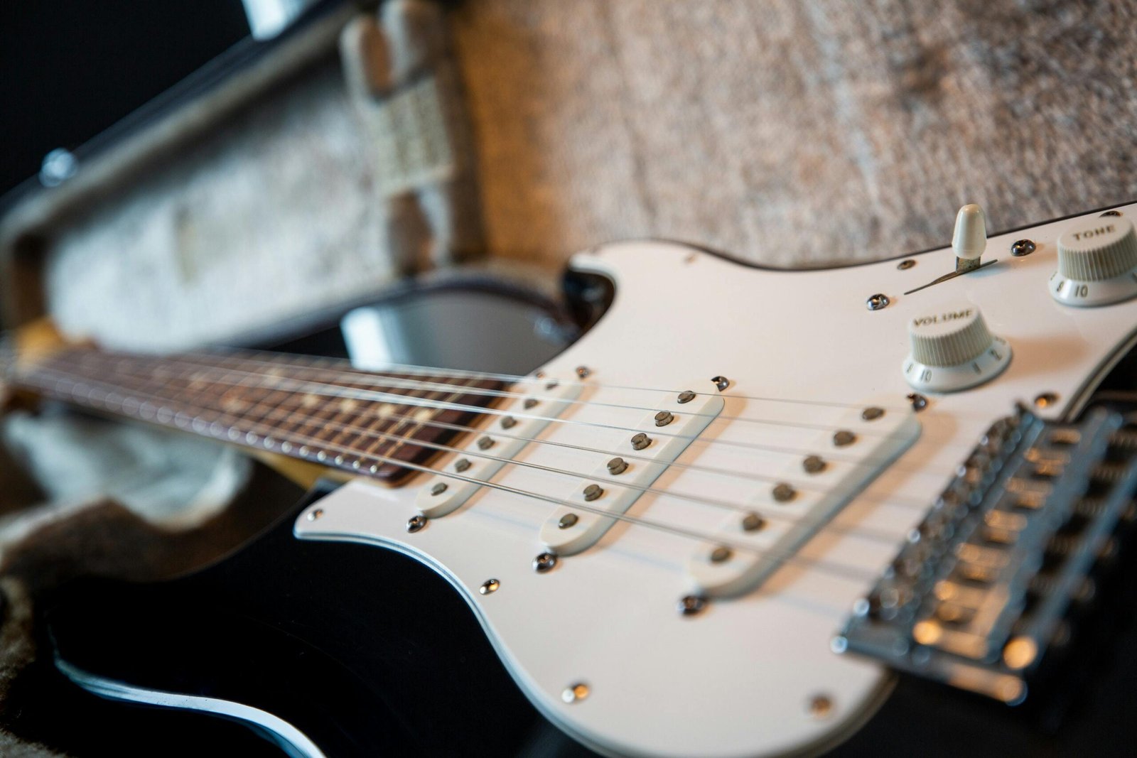 A focused view of a classic electric guitar's body and strings inside its case.